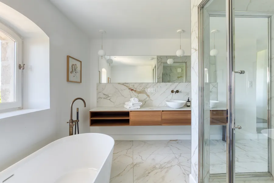 A marble bathroom with a freestanding tub and walk-in shower