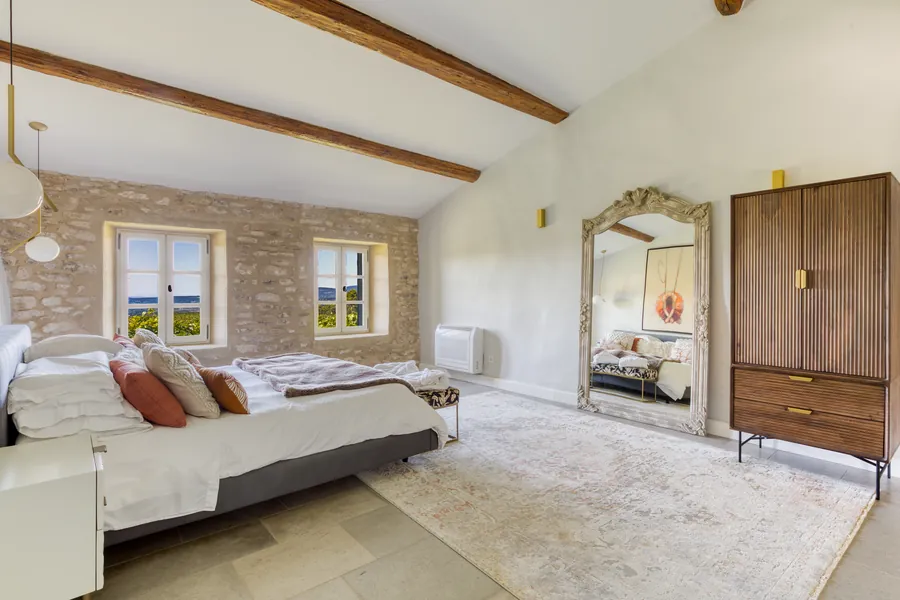 A bedroom with a gilded antique mirror