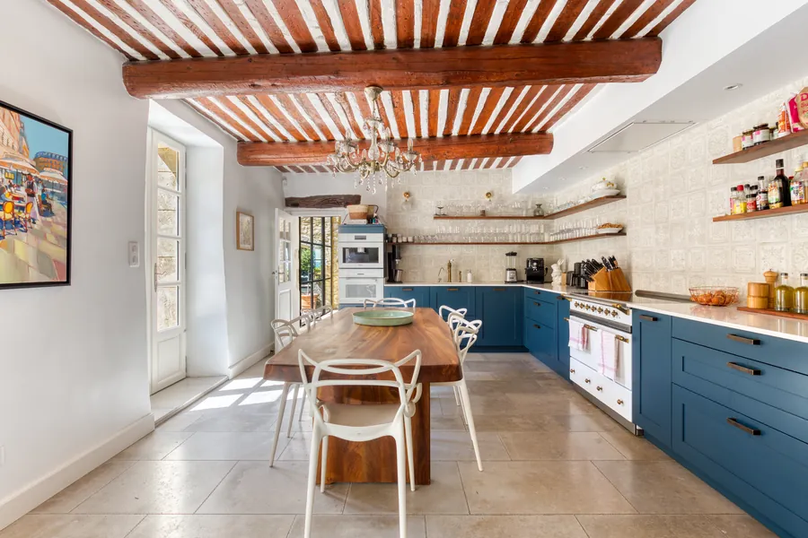 The chef’s kitchen beneath a terracotta-and-beam ceiling